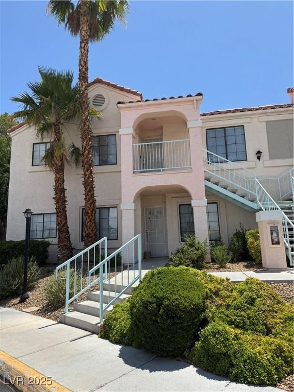 4831 S Torrey Pines Dr Unit 204, Las Vegas, NV 89103 - view of front facade featuring stucco siding, a tiled roof, a balcony, and stairway