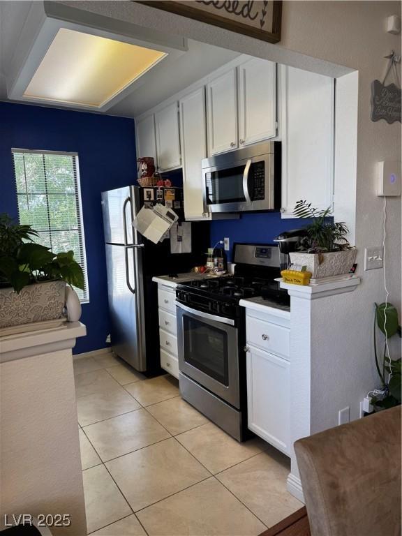 4831 S Torrey Pines Dr Unit 204, Las Vegas, NV 89103 - kitchen with appliances with stainless steel finishes, white cabinets, light tile patterned flooring, and light countertops