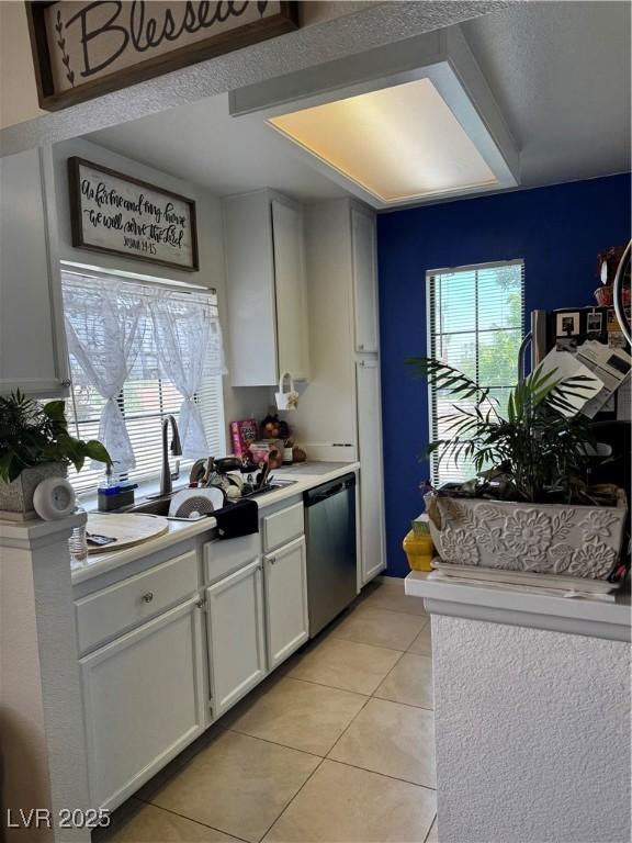 4831 S Torrey Pines Dr Unit 204, Las Vegas, NV 89103 - kitchen featuring dishwasher, light tile patterned floors, light countertops, and white cabinetry