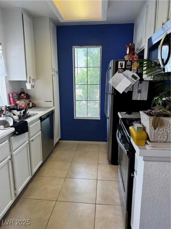 4831 S Torrey Pines Dr Unit 204, Las Vegas, NV 89103 - kitchen with stainless steel appliances, light countertops, light tile patterned flooring, and white cabinets