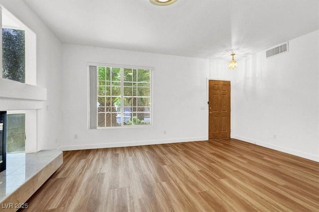 9824 Babys Breath Ct, Las Vegas, NV 89183 - unfurnished living room featuring wood finished floors, a chandelier, and a fireplace