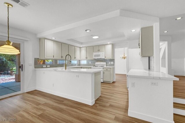 9824 Babys Breath Ct, Las Vegas, NV 89183 - kitchen featuring white appliances, a peninsula, light wood-style floors, and recessed lighting