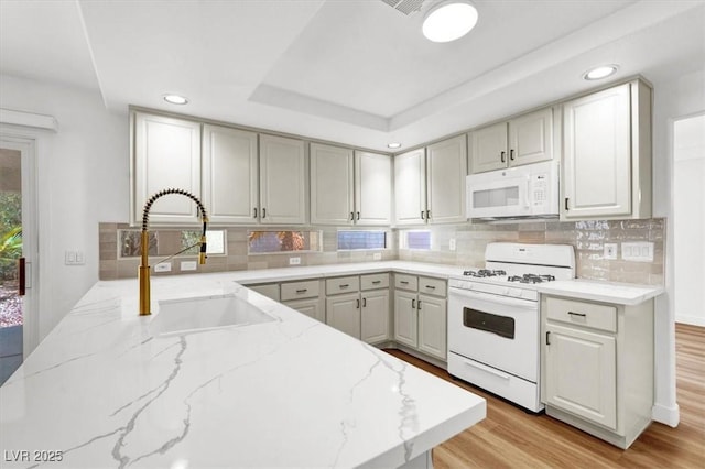 9824 Babys Breath Ct, Las Vegas, NV 89183 - kitchen with white appliances, recessed lighting, light stone counters, light wood-type flooring, and tasteful backsplash