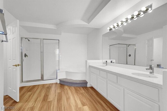 9824 Babys Breath Ct, Las Vegas, NV 89183 - full bathroom featuring a shower stall, double vanity, a garden tub, and wood finished floors