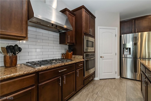 176 Dunblane St, Henderson, NV 89012 - kitchen with stainless steel appliances, wall chimney exhaust hood, stone counters, backsplash, and dark brown cabinetry