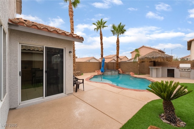 2064 Spiers Ave, Las Vegas, NV 89183 - view of pool featuring an outdoor kitchen, a patio, a fenced backyard, and a pool with connected hot tub