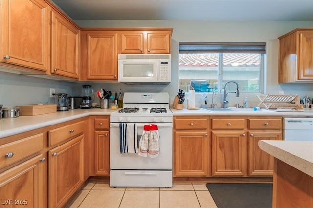 2064 Spiers Ave, Las Vegas, NV 89183 - kitchen with white appliances, light countertops, light tile patterned floors, and brown cabinets