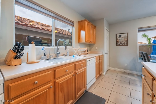 2064 Spiers Ave, Las Vegas, NV 89183 - kitchen featuring dishwasher, light countertops, light tile patterned floors, and brown cabinetry