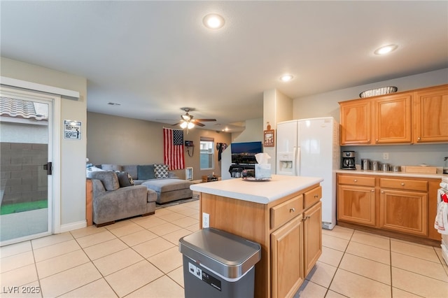 2064 Spiers Ave, Las Vegas, NV 89183 - kitchen with white refrigerator with ice dispenser, light tile patterned floors, light countertops, open floor plan, and a kitchen island