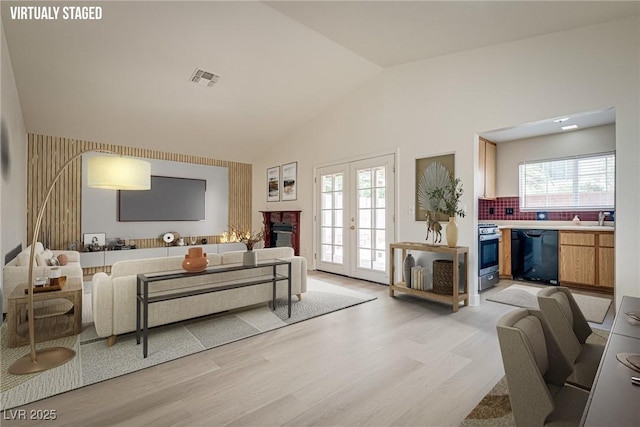 4630 Pratt Way, Las Vegas, NV 89147 - living room featuring a glass covered fireplace, light wood-style floors, and high vaulted ceiling
