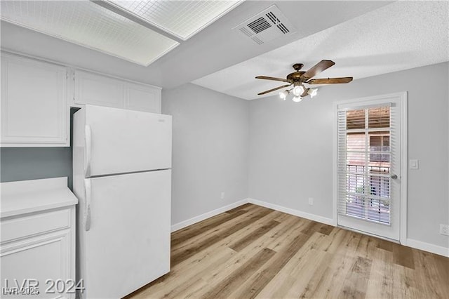 5576 W Rochelle Ave Unit 9C, Las Vegas, NV 89103 - kitchen featuring freestanding refrigerator, white cabinets, light wood-style flooring, ceiling fan, and light countertops