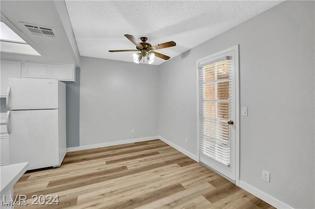 5576 W Rochelle Ave Unit 9C, Las Vegas, NV 89103 - unfurnished dining area featuring a ceiling fan, light wood-style floors, and a textured ceiling