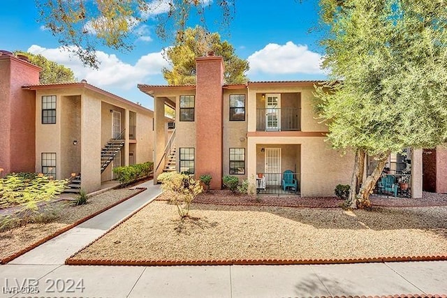 5576 W Rochelle Ave Unit 9C, Las Vegas, NV 89103 - mediterranean / spanish home featuring stairway, stucco siding, and a chimney