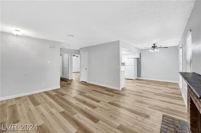 5576 W Rochelle Ave Unit 9C, Las Vegas, NV 89103 - unfurnished living room with a ceiling fan, light wood-type flooring, and a textured ceiling