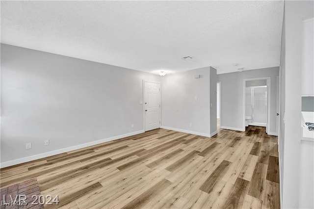 5576 W Rochelle Ave Unit 9C, Las Vegas, NV 89103 - spare room featuring light wood-style flooring and a textured ceiling