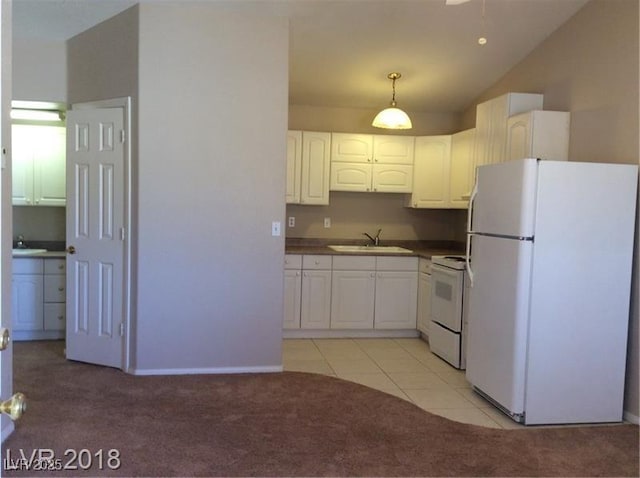 1710 N Murphy St, Pahrump, NV 89060 - kitchen featuring white appliances, light carpet, white cabinetry, dark countertops, and pendant lighting