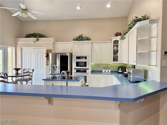 1710 N Murphy St, Pahrump, NV 89060 - kitchen with stainless steel fridge with ice dispenser, white double oven, open shelves, white cabinets, and glass insert cabinets