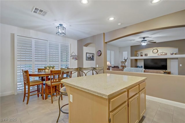7013 Bisoni St, Las Vegas, NV 89149 - kitchen with ceiling fan, a center island, recessed lighting, arched walkways, and light brown cabinetry