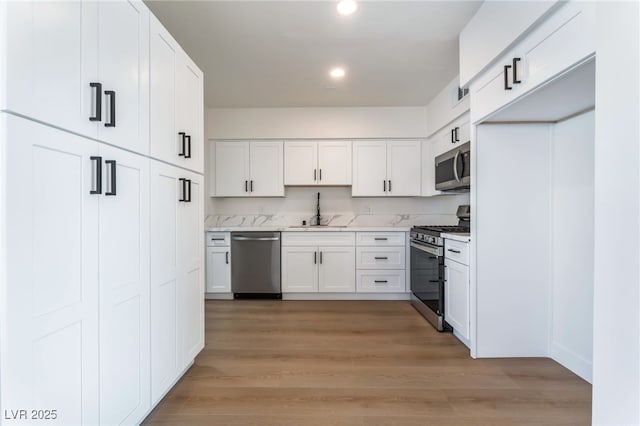 2 Utah Way, Henderson, NV 89015 - kitchen with stainless steel appliances, white cabinetry, light countertops, recessed lighting, and light wood-type flooring