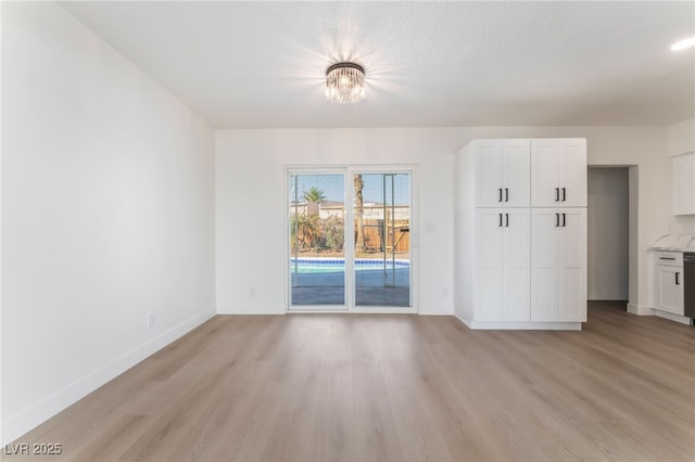 2 Utah Way, Henderson, NV 89015 - unfurnished living room with light wood finished floors and a chandelier