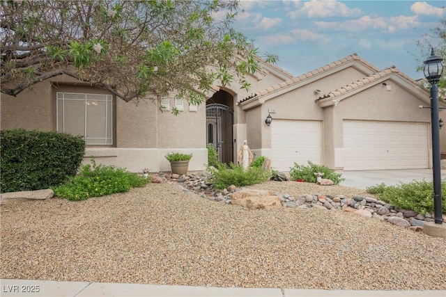 1598 Cowboy Chaps Pl, Henderson, NV 89002 - mediterranean / spanish home with a garage, driveway, stucco siding, and a tiled roof