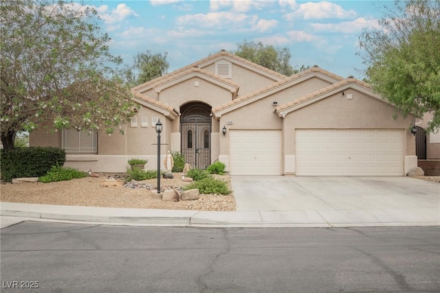 1598 Cowboy Chaps Pl, Henderson, NV 89002 - mediterranean / spanish house featuring an attached garage, concrete driveway, stucco siding, and a tiled roof