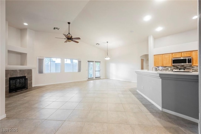 1598 Cowboy Chaps Pl, Henderson, NV 89002 - unfurnished living room featuring ceiling fan, a tile fireplace, light tile patterned floors, high vaulted ceiling, and recessed lighting