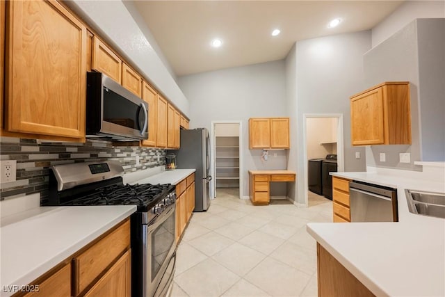 1598 Cowboy Chaps Pl, Henderson, NV 89002 - kitchen featuring appliances with stainless steel finishes, separate washer and dryer, decorative backsplash, a towering ceiling, and light tile patterned flooring