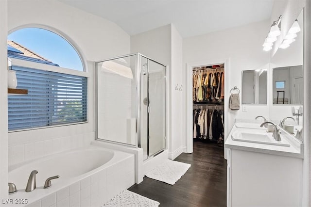 8325 Winterchase Pl, Las Vegas, NV 89143 - bathroom with a stall shower, a bath, double vanity, wood finished floors, and a walk in closet