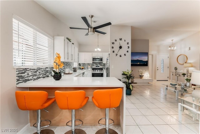 2093 Seahurst Dr, Las Vegas, NV 89142 - kitchen with stainless steel appliances, a ceiling fan, decorative backsplash, a peninsula, and light countertops