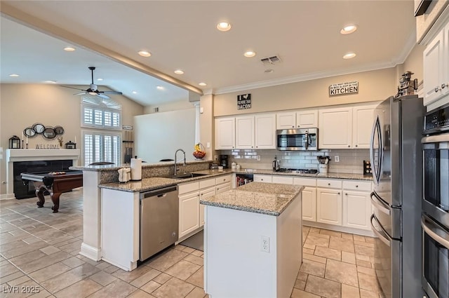 7404 Wittig Ave, Las Vegas, NV 89131 - kitchen with stainless steel appliances, a ceiling fan, a peninsula, white cabinetry, and backsplash