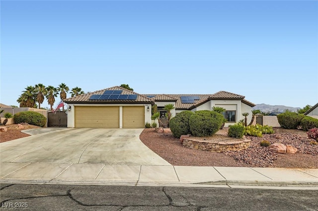 7404 Wittig Ave, Las Vegas, NV 89131 - view of front of house featuring stucco siding, an attached garage, concrete driveway, solar panels, and a gate