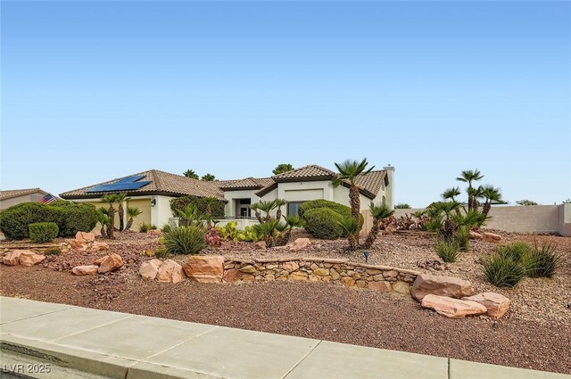 7404 Wittig Ave, Las Vegas, NV 89131 - mediterranean / spanish-style home with an attached garage, stucco siding, roof mounted solar panels, and a tile roof