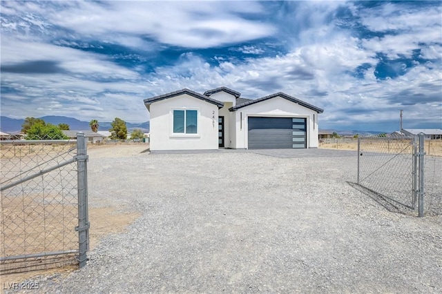 2461 S Blagg Rd, Pahrump, NV 89048 - ranch-style house featuring a gate, driveway, a garage, stucco siding, and a mountain view
