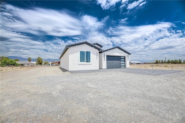 2461 S Blagg Rd, Pahrump, NV 89048 - view of front of home featuring gravel driveway, a garage, stucco siding, and a tiled roof