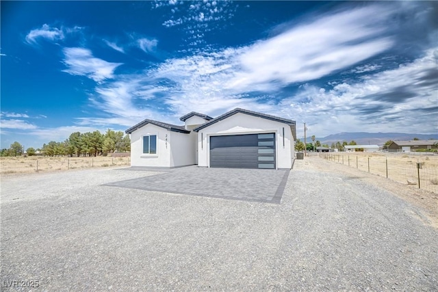 2461 S Blagg Rd, Pahrump, NV 89048 - view of front of property featuring driveway, stucco siding, a mountain view, and a garage
