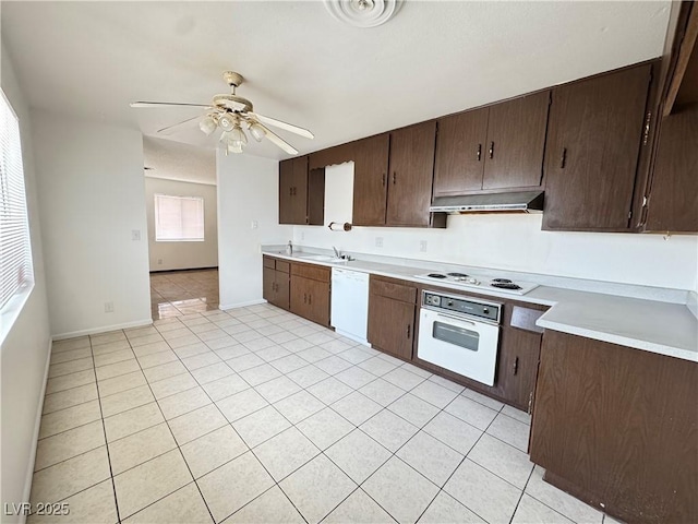 4303 Paramount St, Las Vegas, NV 89115 - kitchen featuring white appliances, under cabinet range hood, light countertops, light tile patterned floors, and ceiling fan