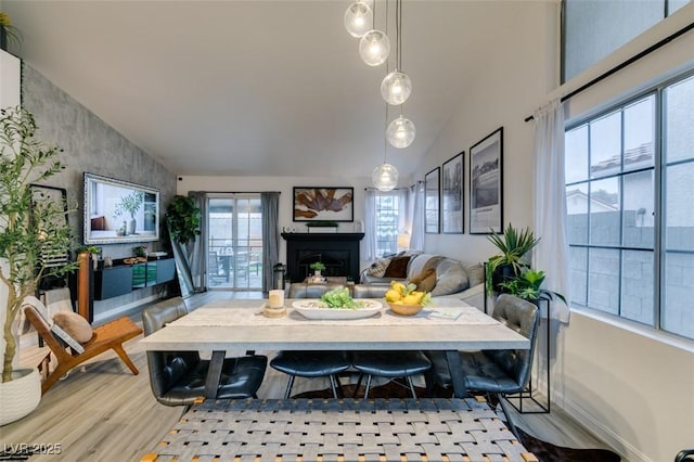 640 Thornewood Pl, Las Vegas, NV 89123 - dining space featuring lofted ceiling, a fireplace, wood finished floors, and plenty of natural light