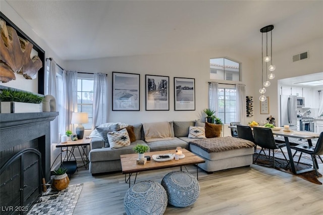 640 Thornewood Pl, Las Vegas, NV 89123 - living room featuring lofted ceiling, light wood finished floors, and a fireplace with flush hearth