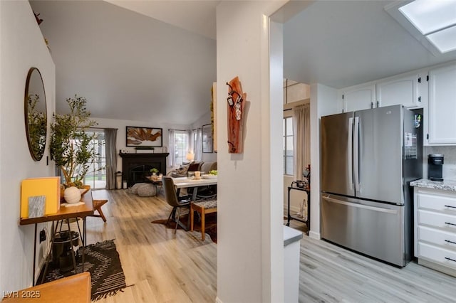 640 Thornewood Pl, Las Vegas, NV 89123 - kitchen featuring freestanding refrigerator, white cabinetry, light wood-style flooring, a fireplace, and open floor plan