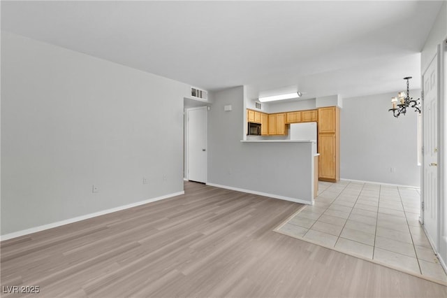 5710 E Tropicana Ave Unit 1184, Las Vegas, NV 89122 - unfurnished living room with a chandelier and light wood-type flooring