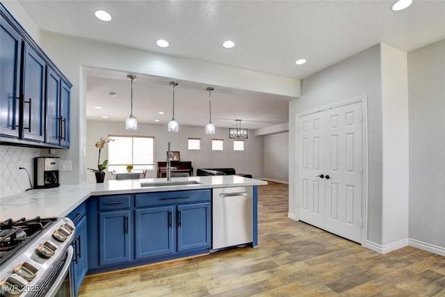 2766 Mintlaw Ave, Henderson, NV 89044 - kitchen with appliances with stainless steel finishes, a peninsula, blue cabinets, backsplash, and light wood-style flooring
