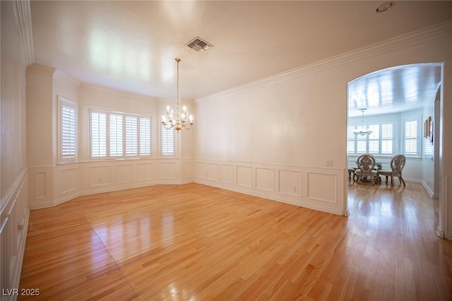 8925 Wild Creek Ct, Las Vegas, NV 89117 - empty room with a chandelier, a decorative wall, light wood finished floors, a wainscoted wall, and ornamental molding