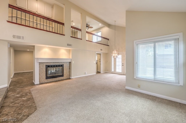 56 Westheimer Rd, Henderson, NV 89074 - unfurnished living room with high vaulted ceiling, a fireplace with flush hearth, a ceiling fan, a chandelier, and carpet