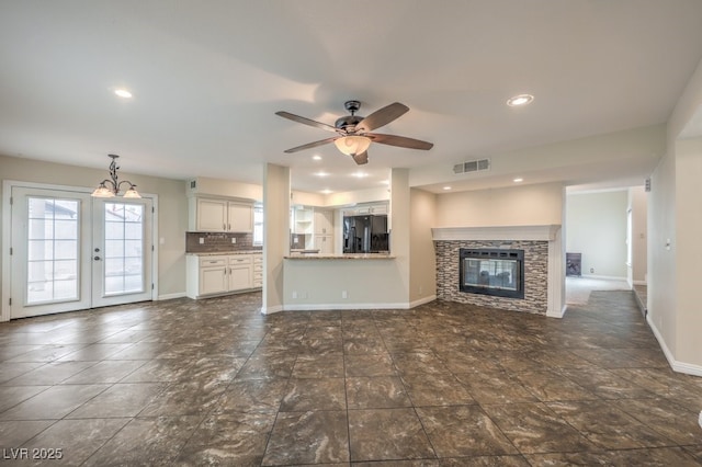 56 Westheimer Rd, Henderson, NV 89074 - unfurnished living room with a glass covered fireplace, ceiling fan, recessed lighting, french doors, and a chandelier