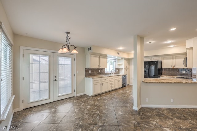 56 Westheimer Rd, Henderson, NV 89074 - kitchen featuring black fridge, backsplash, dishwasher, white cabinets, and light stone counters