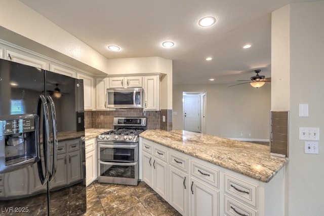 56 Westheimer Rd, Henderson, NV 89074 - kitchen featuring appliances with stainless steel finishes, a peninsula, a ceiling fan, backsplash, and white cabinetry