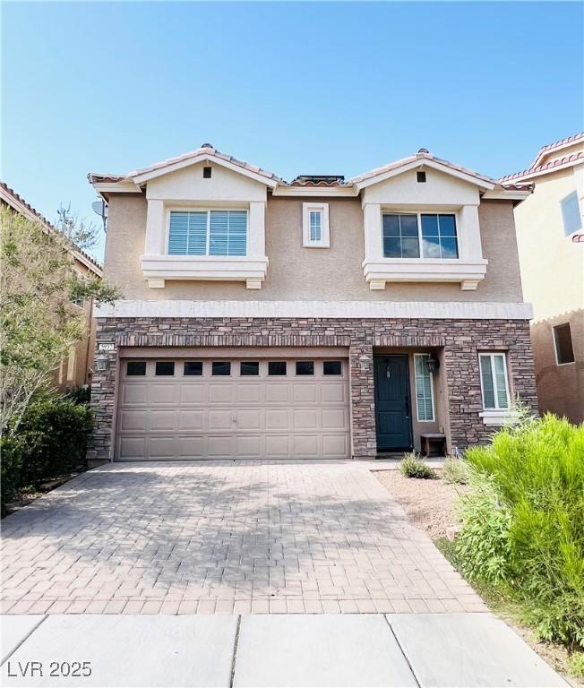 5932 Pillar Rock Ave, Las Vegas, NV 89139 - traditional home with stucco siding, stone siding, decorative driveway, and a garage