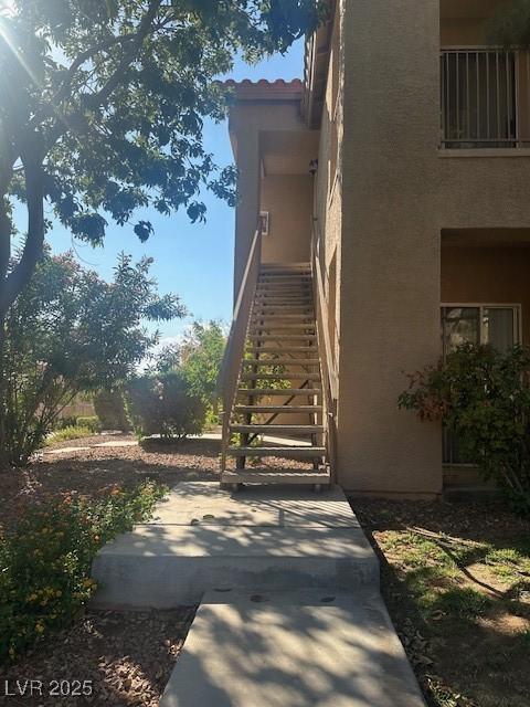 2110 Los Feliz St Unit 2091, Las Vegas, NV 89156 - view of side of property with stucco siding, stairs, and a patio