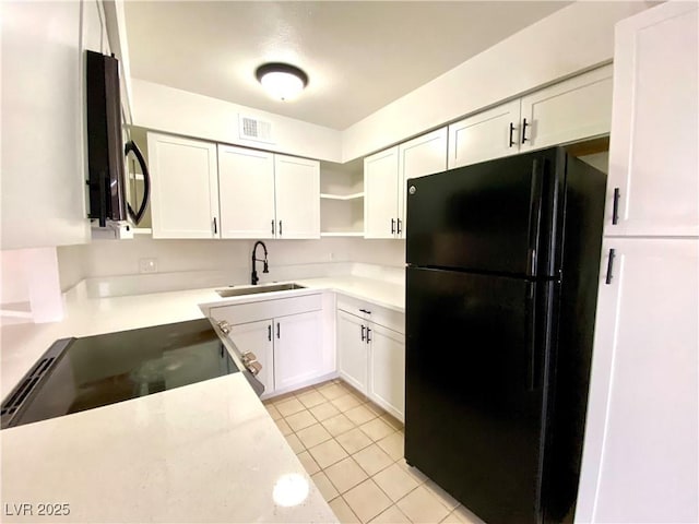 4980 Apollostar Ct, Las Vegas, NV 89115 - kitchen featuring freestanding refrigerator, open shelves, white cabinetry, and light countertops